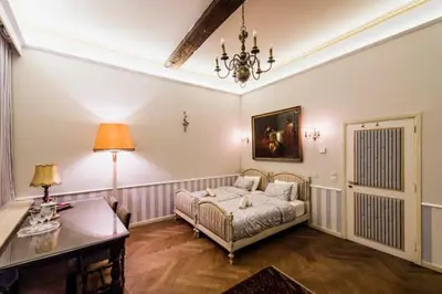 a bedroom with a bed and a table and a lamp at HOFMARKGRAAF - Unique apartment in historic Antwerp mansion in Antwerp