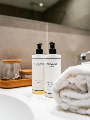 two bottles of sunscreen sitting on a bathroom counter at Bloomhotel in Lochristi