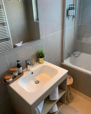 a bathroom with a sink and a shower and a tub at Bloomhotel in Lochristi