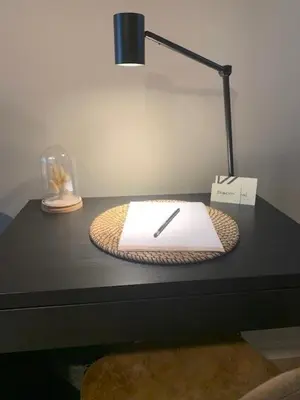 a desk with a lamp and a book on it at Bloomhotel in Lochristi