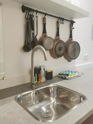a kitchen sink with utensils hanging on a wall at SHWAY - The Red Monkey in Antwerp