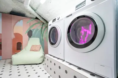 a washing machine in a room with a chair at SHWAY - The Blue Parrot in Antwerp