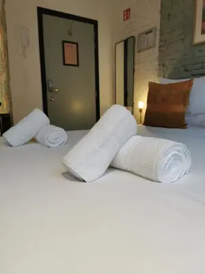 two rolls of white towels sitting on a bed at SHWAY - The Light Blue Parrot in Antwerp