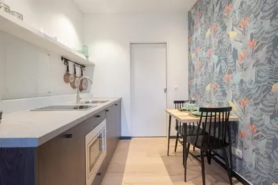 a kitchen with a sink and a table with chairs at SHWAY - The Light Blue Parrot in Antwerp