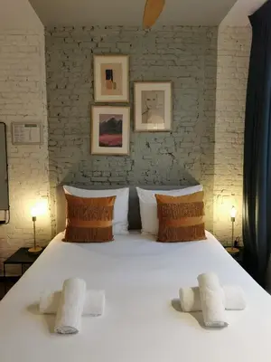 a bedroom with a large white bed with three pillows at SHWAY - The Light Blue Parrot in Antwerp