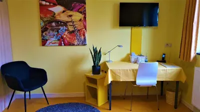 a room with a table with two chairs and a tv at Hotel Amethist in Ramsel