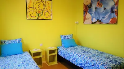 two beds in a room with yellow walls at Hotel Amethist in Ramsel