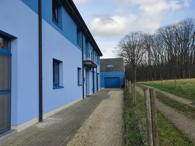 a white building with a blue door and a fence at Hotel Amethist in Ramsel