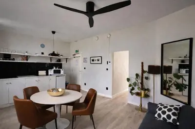 a living room with a table and a ceiling fan at Modern Cityflat at Theaterdistrict in Antwerp