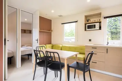 a kitchen and dining room with a table and chairs at Verblijfpark Tulderheyde in Poppel