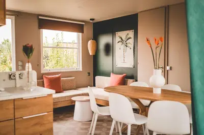 a kitchen and dining room with a table and chairs at Verblijfpark Tulderheyde in Poppel