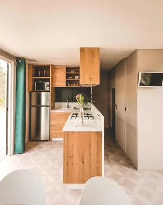 a kitchen with wooden cabinets and a white counter top at Verblijfpark Tulderheyde in Poppel
