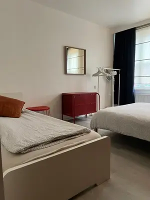 a bedroom with two beds and a mirror and a window at Elma’s Place in Ghent