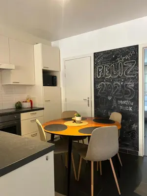 a kitchen with a table with chairs and a chalkboard at Elma’s Place in Ghent