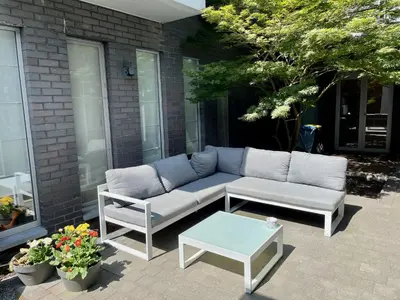 a couch and a coffee table on a patio at Luxurious villa during tomorrowland in Hemiksem