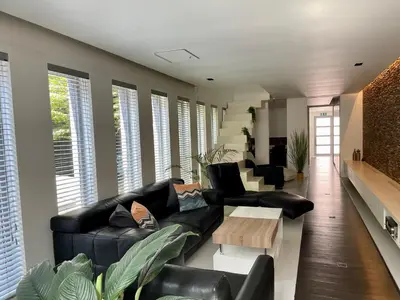 a living room with a black couch and a table at Luxurious villa during tomorrowland in Hemiksem