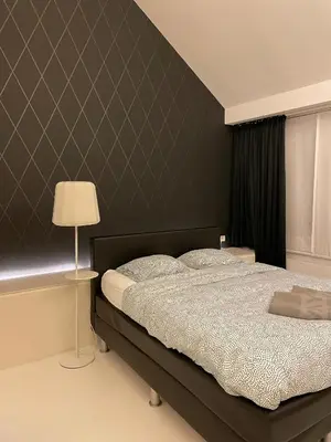 a bedroom with a large bed and a lamp at Luxurious villa during tomorrowland in Hemiksem