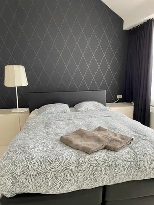 a bedroom with a bed with a blanket on it at Luxurious villa during tomorrowland in Hemiksem