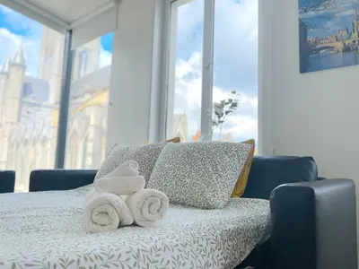 a bed with towels on it with a window at Duplex Apartment in the Heart of Ghent with Fantastic Views in Ghent
