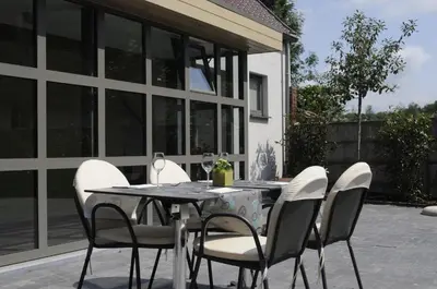 a dining table with white chairs and a table and chairsktop at Gastenhof Ter Lombeek in Onze-Lieve-Vrouw-Lombeek