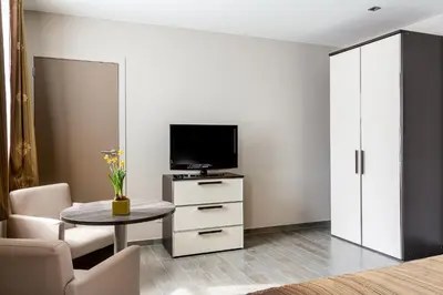 a living room with a tv and a table at Gastenhof Ter Lombeek in Onze-Lieve-Vrouw-Lombeek