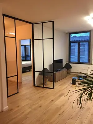 a living room with a large mirror in a room at Kloosterloft in Antwerp