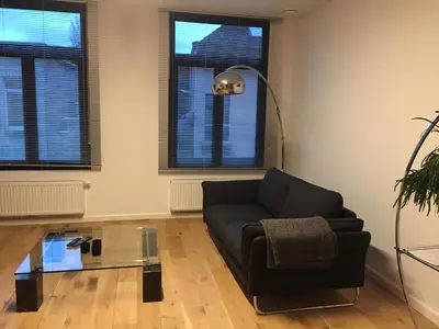 a living room with a couch and a glass table at Kloosterloft in Antwerp