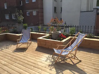 two chairs sitting on a patio with flowers at Kloosterloft in Antwerp