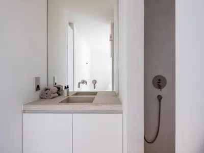 a white bathroom with a sink and a mirror at Maison N in Ghent