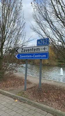 a street sign in front of a river at Panda Bella in Zaventem