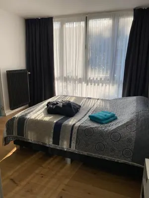 a bedroom with a bed with blue towels on it at Appartement met groot terras in Mortsel
