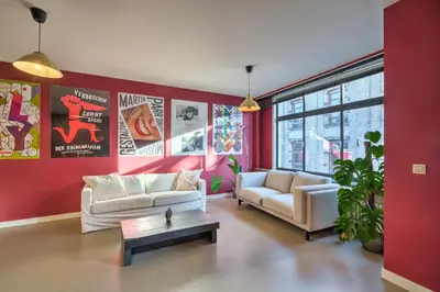 a living room with two couches and a red wall at Apartment with Rooftop Terrace in the Heart of Antwerp in Antwerp