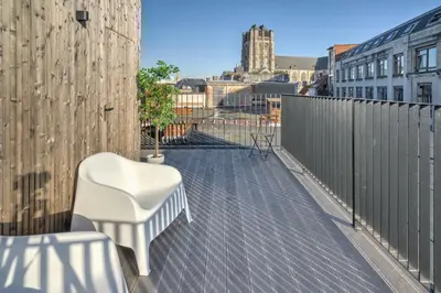 a balcony with a white chair and a fence at Apartment with Rooftop Terrace in the Heart of Antwerp in Antwerp