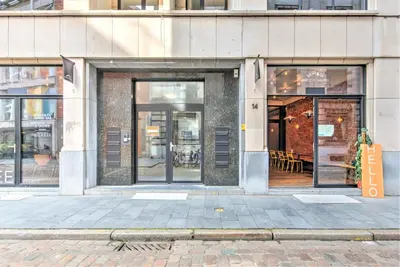 a store front with glass doors on a city street at Apartment with Rooftop Terrace in the Heart of Antwerp in Antwerp