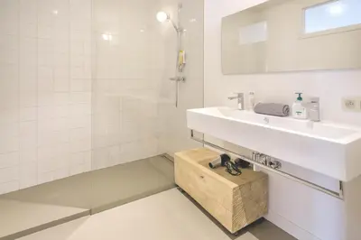 a white bathroom with a sink and a mirror at Apartment with Rooftop Terrace in the Heart of Antwerp in Antwerp