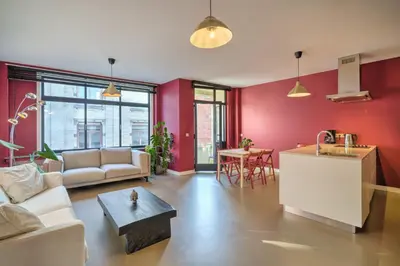 a living room with red walls and a couch and a table at Apartment with Rooftop Terrace in the Heart of Antwerp in Antwerp