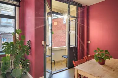 a dining room with red walls and a wooden table at Apartment with Rooftop Terrace in the Heart of Antwerp in Antwerp