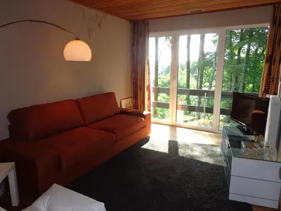 a living room with a couch and a large window at Green Hill Apartment Overijse in Overijse