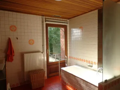 a bathroom with a bath tub and a window at Green Hill Apartment Overijse in Overijse