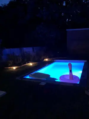 a swimming pool at night with a bottle in it at B & B Simme Zimme in Brasschaat