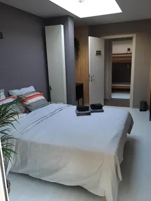 a bedroom with a large white bed with two pillows at B & B Simme Zimme in Brasschaat