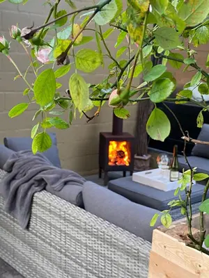 a living room with a blue couch and a fireplace at B & B Simme Zimme in Brasschaat