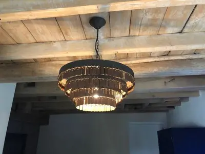 a chandelier hanging from a wooden ceiling at B&B Langeveldemolen in Merchtem