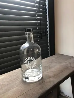 a glass bottle sitting on top of a wooden table at B&B Langeveldemolen in Merchtem