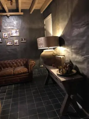a living room with a couch and a table with a lamp at B&B Langeveldemolen in Merchtem