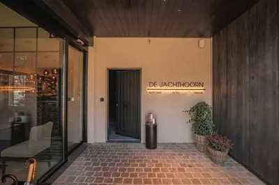 a entrance to a building with a door and a plant at Hotel De Jachthoorn in Hoogstraten