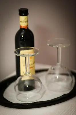 two wine glasses on a tray with a bottle of wine at JFK Hotel Zelzate - Gent in Zelzate