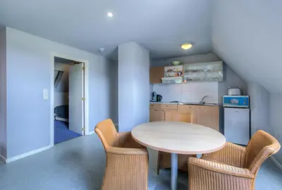 a kitchen with a table and chairs in a room at JFK Hotel Zelzate - Gent in Zelzate