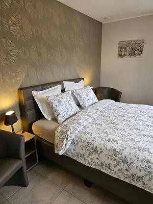 a bedroom with a bed and a chair at B&B OLEN in Olen