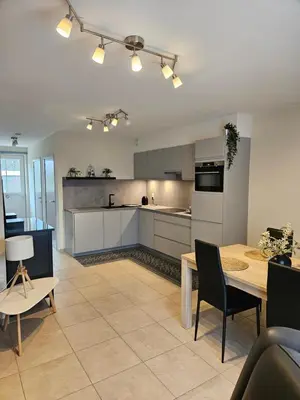 a kitchen with a table and a dining room at B&B OLEN in Olen